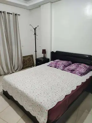 a bedroom with a large bed with purple pillows at Appartement de vacances in Oulad Akkou