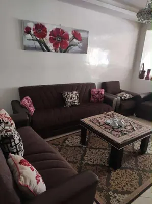 a living room with a couch and a coffee table at Appartement de vacances in Oulad Akkou