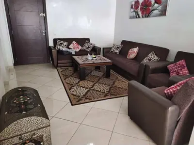 a living room with couches and a coffee table at Appartement de vacances in Oulad Akkou