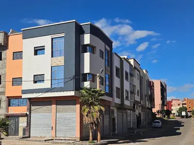 a building with a palm tree in front of it at appartement luxueux khenifra 1 in Khenifra