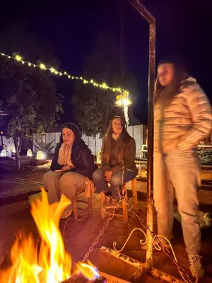 a group of people sitting around a fire at Sahary Tafilalt Luxury Camp in Merzouga