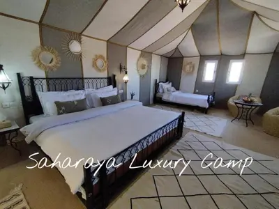 a bedroom with a large bed in a room at Sahary Tafilalt Luxury Camp in Merzouga