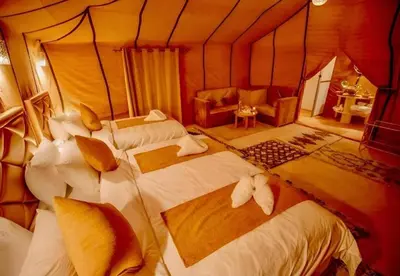 a bedroom with three beds in a room at Host Luxury Camp in Merzouga