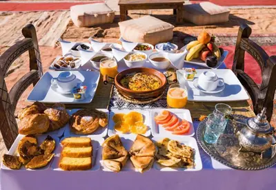 a table with a blue table cloth with food on it at Host Luxury Camp in Merzouga