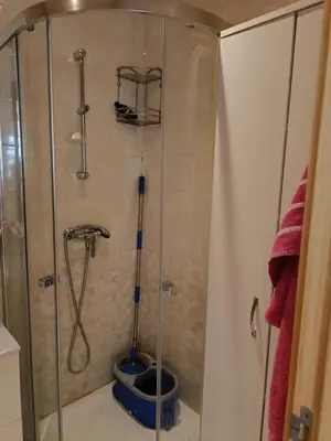 a shower with a glass door in a bathroom at Appartement dans une résidence balnéaire à Sidi Rehal in Oulad Akkou