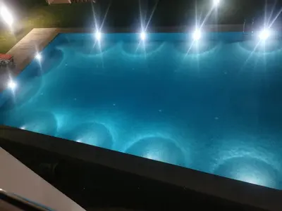 a swimming pool with lights on top of it at Appartement dans une résidence balnéaire à Sidi Rehal in Oulad Akkou