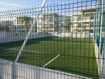 a view of a tennis court through a net at Appartement dans une résidence balnéaire à Sidi Rehal in Oulad Akkou