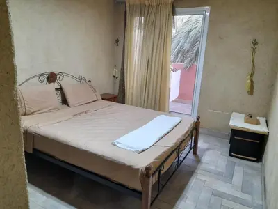 a bedroom with a bed with a window and a door at Village al baraka in Oulad Akkou