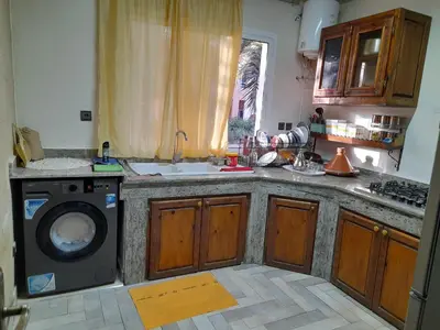 a kitchen with a sink and a washing machine at Village al baraka in Oulad Akkou