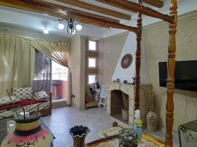 a living room with a fireplace and a couch at Village al baraka in Oulad Akkou