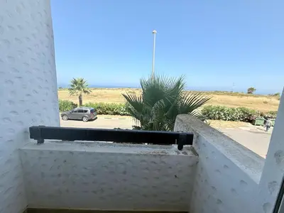 a balcony with a view of the desert and a car at Marina Asilah golf, tennis pool in Oulad Akkou
