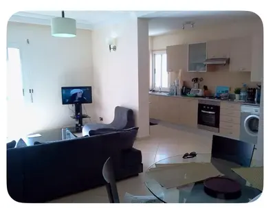 a living room with a couch and a glass table at Marina Asilah golf, tennis pool in Oulad Akkou
