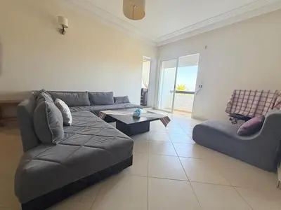a living room with a couch and a table at Marina Asilah golf, tennis pool in Oulad Akkou