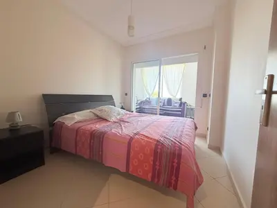 a bedroom with a bed and a large window at Marina Asilah golf, tennis pool in Oulad Akkou