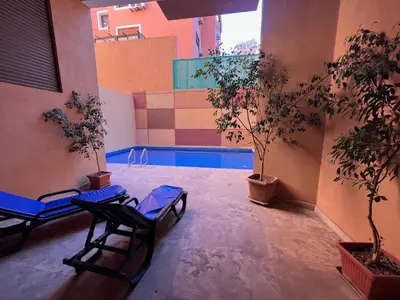 a courtyard with two chairs and a swimming pool at Appartement de Pause Intérieure in Oulad Akkou