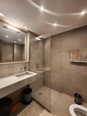 a bathroom with a sink and a glass shower at Appartement de Pause Intérieure in Oulad Akkou