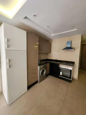 a kitchen with a white refrigerator and a dishwasher at Appartement de Pause Intérieure in Oulad Akkou