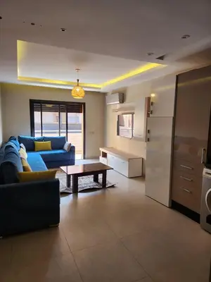 a living room with a blue couch and a table at Appartement de Pause Intérieure in Oulad Akkou