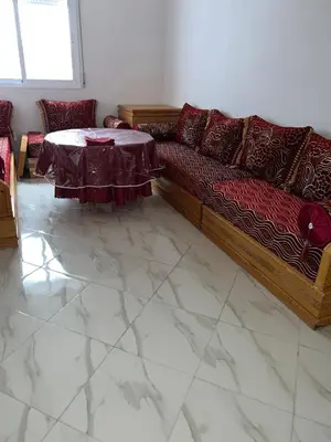 a living room with a couch and a table at Appartement in Oulad Akkou