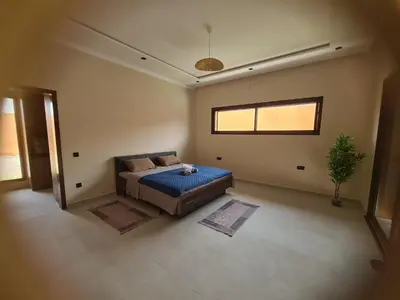 a large bedroom with a bed and a window at Villa avec piscine privée in Oulad Akkou