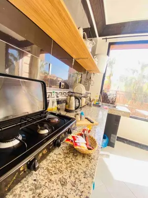 a kitchen with a stove and a counter top at Villas Appart Hotel in Oulad Akkou