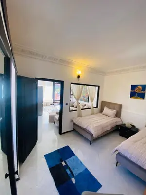 a large bedroom with a bed and a mirror at Villas Appart Hotel in Oulad Akkou