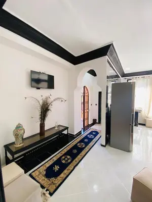 a living room with white walls and black accents at Villas Appart Hotel in Oulad Akkou