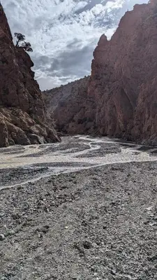 a river in the middle of a canyon with mountains at Almarkaz Assiyahi
