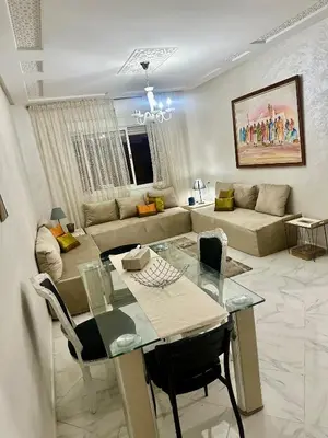 a living room with a table and a couch at Appartement a louer meknes in Meknès