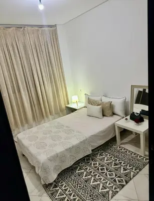 a bedroom with a bed and a table at Appartement a louer meknes in Meknès