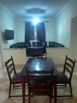 a dining room with a table and two chairs at Saidia in Oulad Akkou