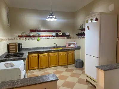 a kitchen with yellow cabinets and a white refrigerator at Saidia in Oulad Akkou