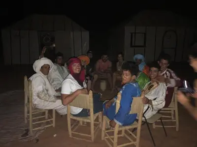 a group of people sitting around a table at desertcamp in Merzouga