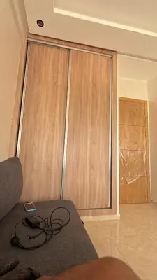 a room with wooden sliding doors in a room at Chambre, appartement Anas in Oulad Akkou