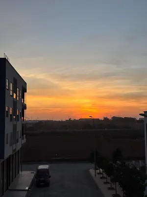 a car parked in a parking lot at sunset at Chambre, appartement Anas in Oulad Akkou