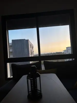 a room with a window with a candle on a bed at Chambre, appartement Anas in Oulad Akkou