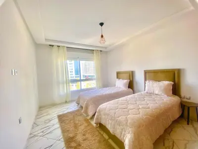 a bedroom with two beds and a window at Maison Hijaz in Oulad Akkou