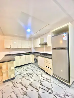 a kitchen with white cabinets and a stainless steel refrigerator at Maison Hijaz in Oulad Akkou