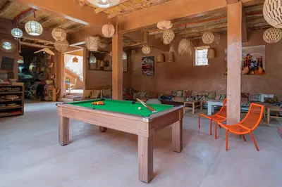 a living room with a pool table and chairs at Riad Azelia