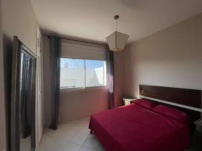 a bedroom with a red bed and a window at Villa skhirat swimming pool in Oulad Akkou