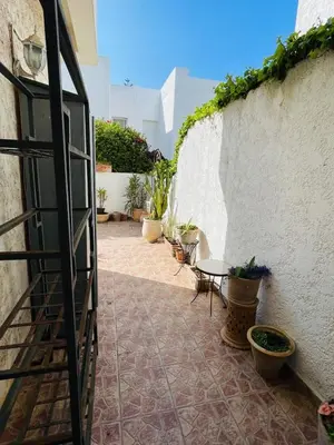 a patio with a table and chairs next to a wall at Villa skhirat swimming pool in Oulad Akkou