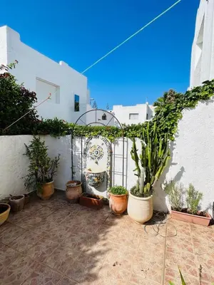 a courtyard with potted plants in front of a building at Villa skhirat swimming pool in Oulad Akkou