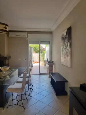 a kitchen with a table and chairs in a room at Villa skhirat swimming pool in Oulad Akkou