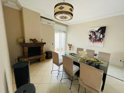 a dining room with a table and chairs and a fireplace at Villa skhirat swimming pool in Oulad Akkou