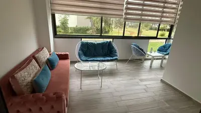 a living room with two chairs and a table at Appartement in Oulad Akkou