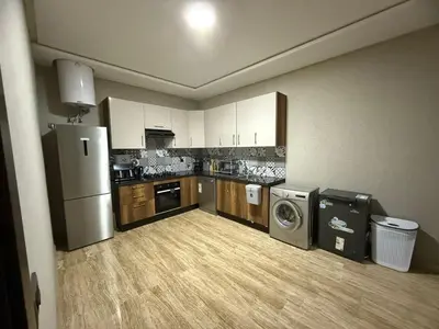a kitchen with a refrigerator and a washer and dryer at Appartement in Oulad Akkou