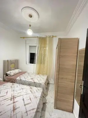 a bedroom with two beds and a window at Cala iris in Oulad Akkou