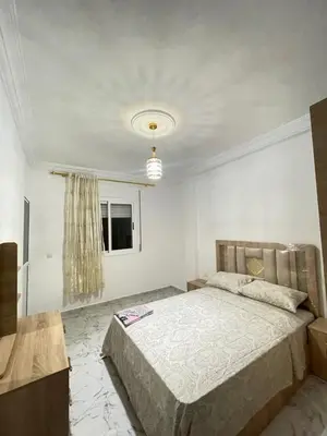 a bedroom with a bed in a white room at Cala iris in Oulad Akkou