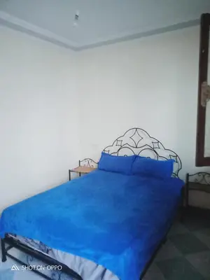 a bedroom with a bed with a blue bedspread at Essaouira Mogador in Oulad Akkou