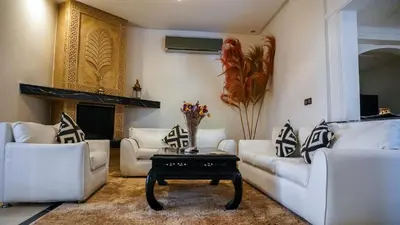 a living room with white couches and a table at Villa Palmyra, 8 suites et piscine chauffée in Marrakech